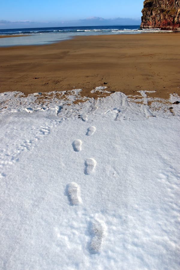 Snow prints on empty beach