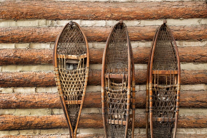 Snow shoes and a log cabin royalty free stock photos