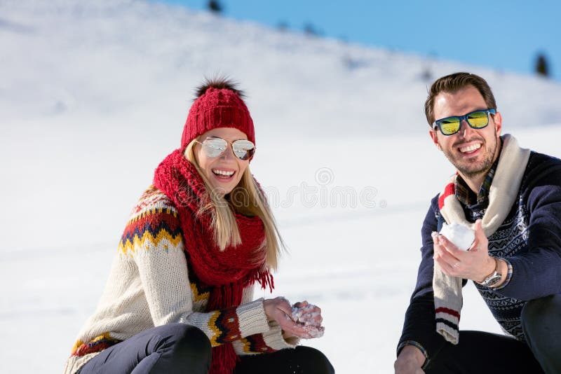 Snowball fight. Winter couple having fun playing in snow outdoors. Young joyful happy multi-racial couple. stock images Snowball fight. Winter couple having fun playing in snow outdoors. Young joyful happy multi-racial couple. stock images