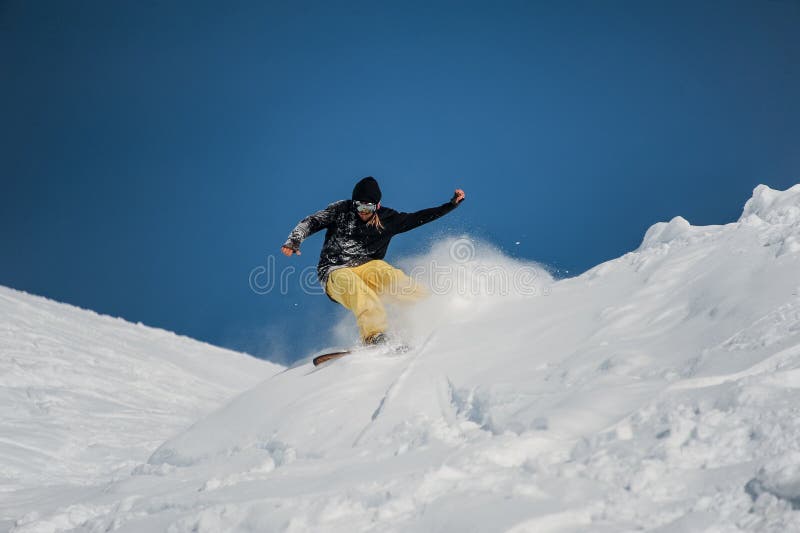Snowboarder de Freeride en el salto en altas montañas en el día soleado foto de archivo libre de regalías Snowboarder de Freeride en el salto en altas montañas en el día soleado foto de archivo libre de regalías