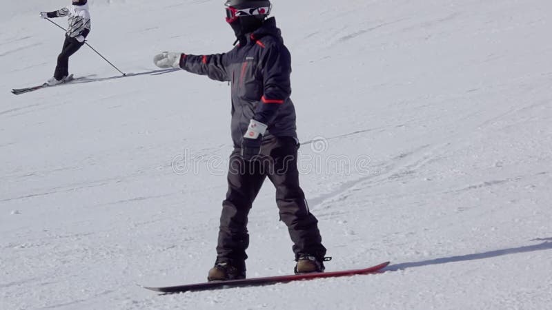 Snowboarder en meisjesskier op de skipiste. langzame beweging