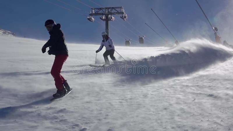 Snowboarder en Skier op een skihelling Langzame beweging