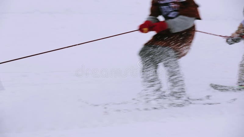 Snowboarder en skiërrit op sneeuwscooterholding op kabel Het van brandstof voorzien van de benzinepomp Sport