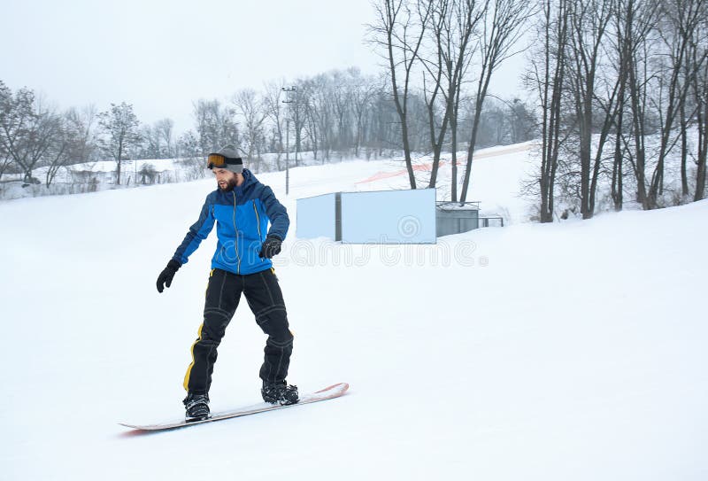Snowboarder masculino na inclinação no recurso do inverno foto de stock Snowboarder masculino na inclinação no recurso do inverno foto de stock