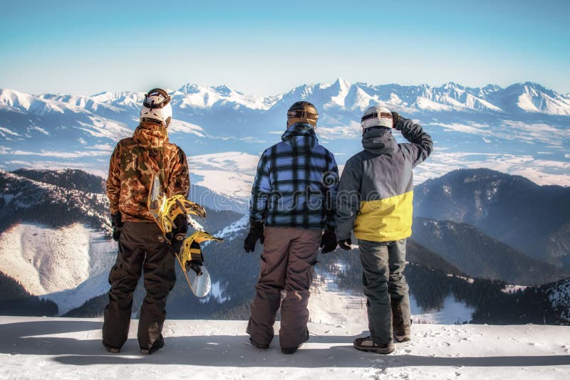 Snowboardista a ľudia, ktorí sa pozerajú na zasnežené hory
