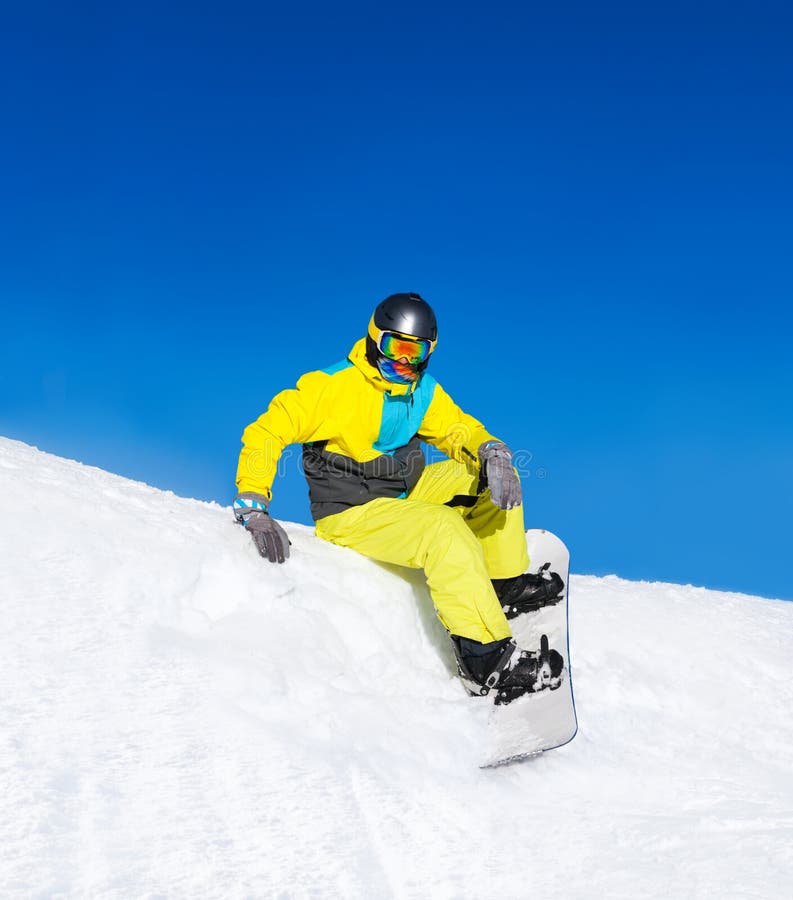 A Snowboarder Sitting on the Snowy Winter Mountain Slope of Sochi Ski