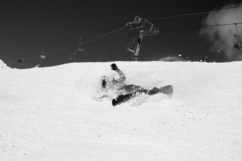 Snowboarder tomber avec des éclaboussures de neige sur piste de ski hors piste. image en noir et blanc image libre de droits