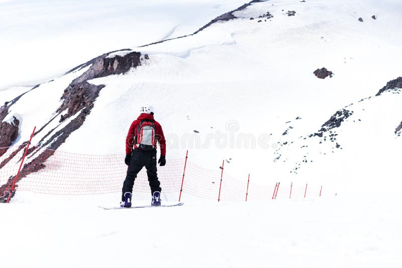 Snowboarder σε ένα κράνος που οδηγά σε μια χιονώδη διαδρομή Γύροι Snowboarder πέρα από το φρέσκο χιόνι στην κλίση το χειμώνα, ακρ στοκ εικόνες Snowboarder σε ένα κράνος που οδηγά σε μια χιονώδη διαδρομή Γύροι Snowboarder πέρα από το φρέσκο χιόνι στην κλίση το χειμώνα, ακρ στοκ εικόνες