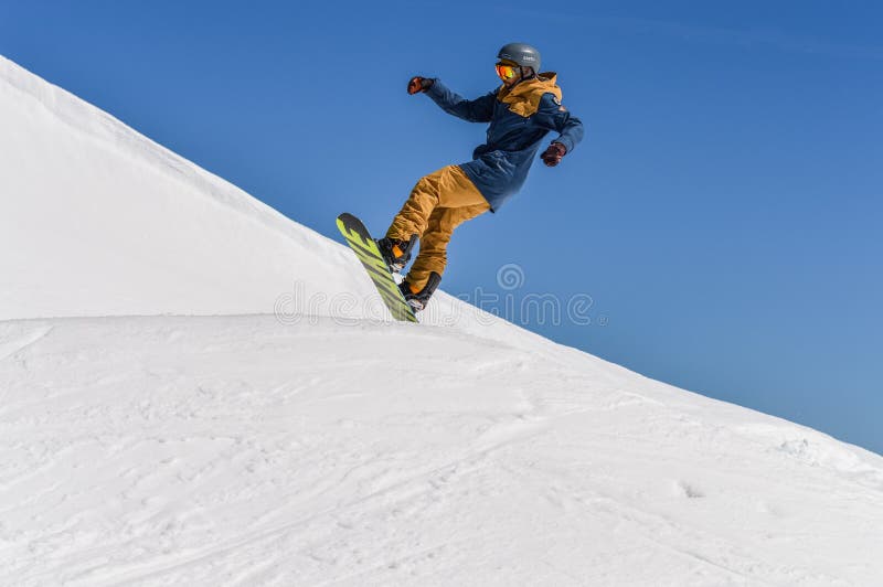 Snowboarder наслаждаясь бегами и скачки на ` s весны продолжают снег стоковое фото Snowboarder наслаждаясь бегами и скачки на ` s весны продолжают снег стоковое фото