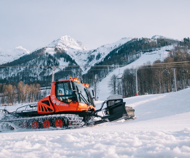 Snowcat red caterdar-fordon för underhåll av skidbackar från bergskidbackar i backskidbacken. royaltyfria foton Snowcat red caterdar-fordon för underhåll av skidbackar från bergskidbackar i backskidbacken. royaltyfria foton