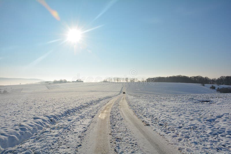 Snowcovered дорога в стране с движущимися машину в таких сферах, как много снега стоковое изображение