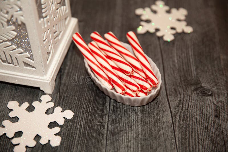 Candy canes with snowflakes flat lay on weathered wood. Candy canes with snowflakes flat lay on weathered wood