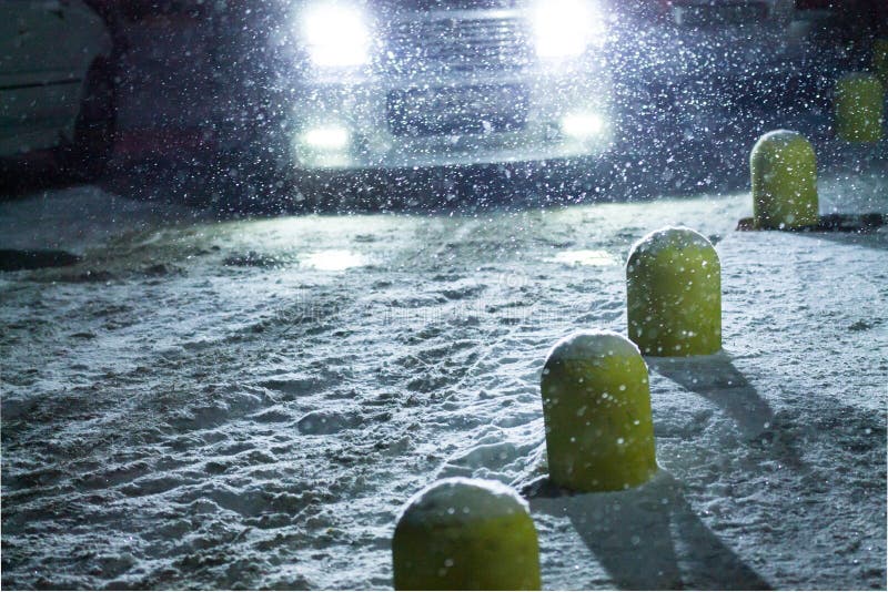 Snowflakes during Snowfall Lit with Light from Car Headlights at Night