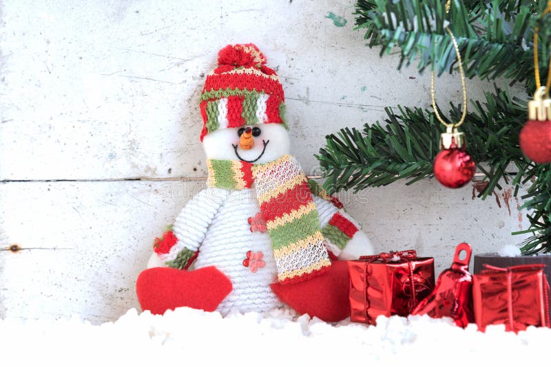 Snowman sitting on the snow with christmas tree royalty free stock photos