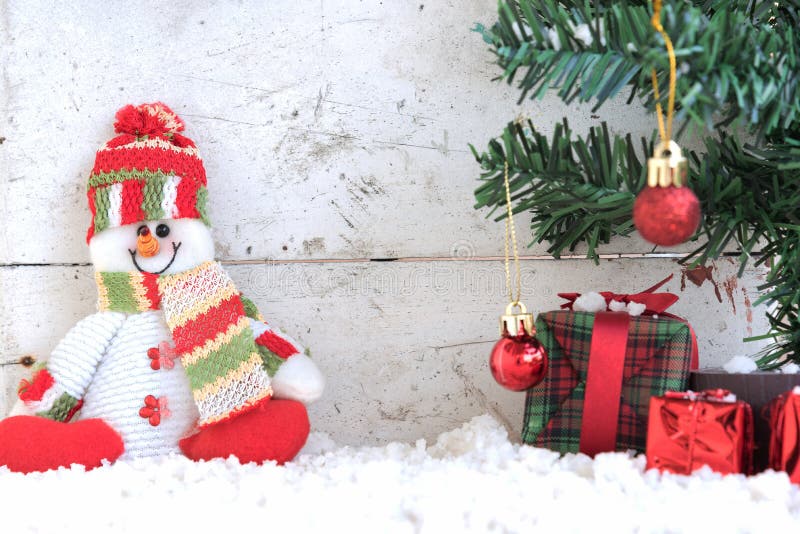 Snowman sitting on the snow with christmas tree in vintage backdrop royalty free stock images