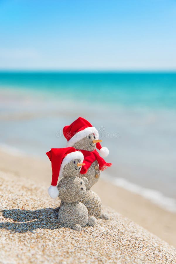 Snowmans couple at sea beach in christmas hat. New years holiday stock images Snowmans couple at sea beach in christmas hat. New years holiday stock images