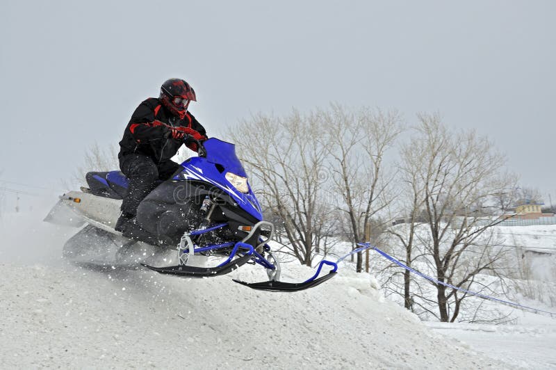 On the snowmobile rider jumps down the mountain royalty free stock image On the snowmobile rider jumps down the mountain royalty free stock image
