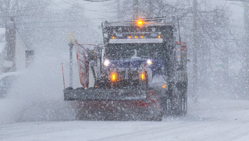 Snowplow plowing a main road during a blizzard in low visability royalty free stock photography