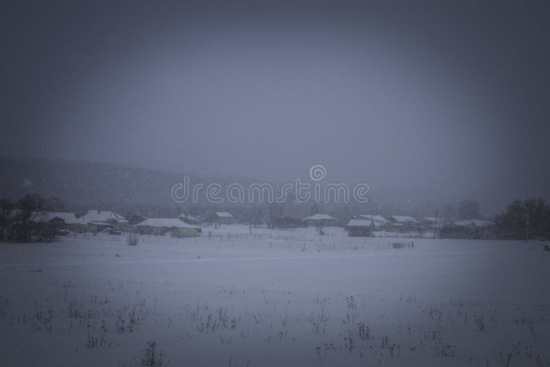 Snowstorm in the village in winter stock photo
