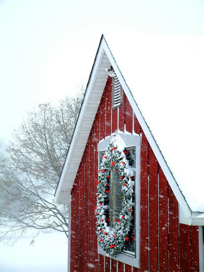 Snowy barn. Snow is falling on a red barn, decorated with a wreath Snowy barn. Snow is falling on a red barn, decorated with a wreath