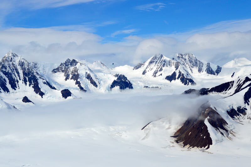 Snowy-Bergspitzen in den Wolken, Nationalpark Kluane, Yukon lizenzfreies stockbild Snowy-Bergspitzen in den Wolken, Nationalpark Kluane, Yukon lizenzfreies stockbild