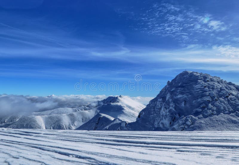 Zasnežené kopce národného parku Nízke Tatry. Výhľad na najvyššie vrchy regiónu - Chopok a Ďumbier. Ďumbier je zahalený v