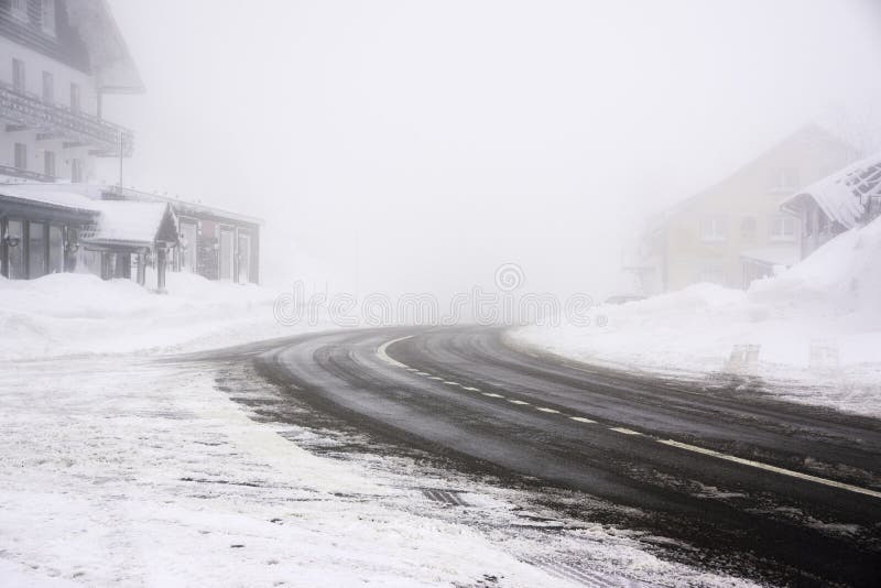 Snowy and icy road curve in a foggy weather - Vosges mountains stock image Snowy and icy road curve in a foggy weather - Vosges mountains stock image