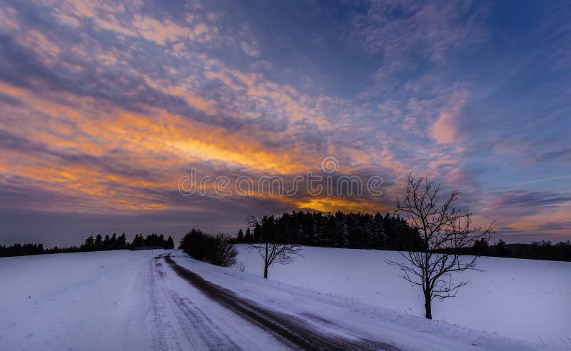 Snowy-Landschaft und -straße bei Sonnenuntergang stockfotografie Snowy-Landschaft und -straße bei Sonnenuntergang stockfotografie