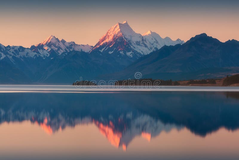 Snowy mountain range reflected in the still water of Lake Pukaki, Mount Cook, South Island, New Zealand. The turquoise water.