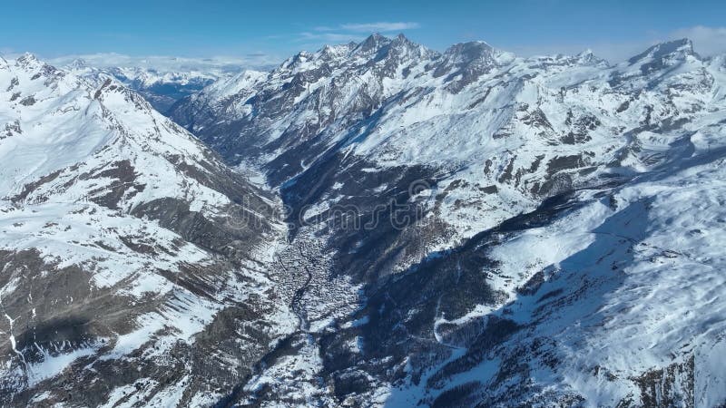 Snowy mountain valley and township. Aerial drone moving forward stock video