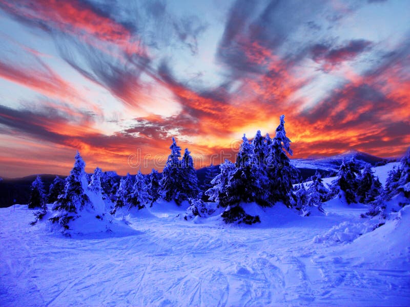 L'inverno con la neve in montagna al crepuscolo, con cielo drammatico.