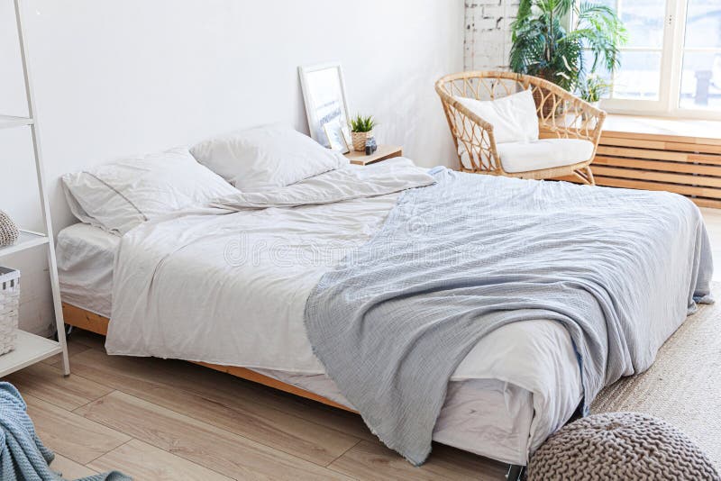 Snygg sovrumslig insida. rymlig designlägenhet med ljusväggar stora fönster stor bädd. ren modern dekoration med arkivbild