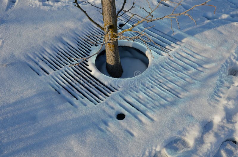 Snöfall med ett litet snöskikt. ett rutnät med runt hål arkivfoto