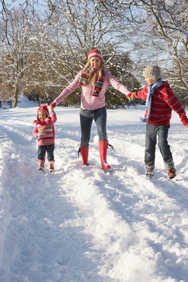 Mother Walking With Children Through Snowy Landscape Having Fun. Mother Walking With Children Through Snowy Landscape Having Fun