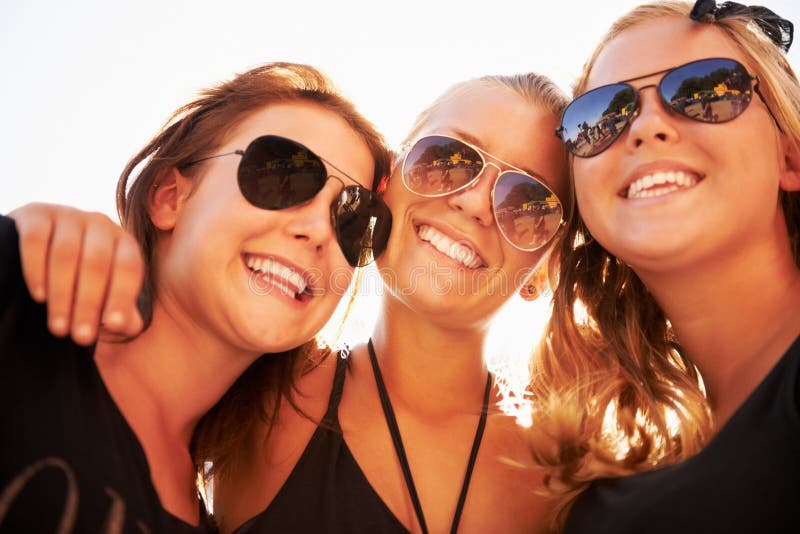 Soaking Up the Sun. Three Friends Hugging and Smiling Against a Bright Sky. Stock Image Image