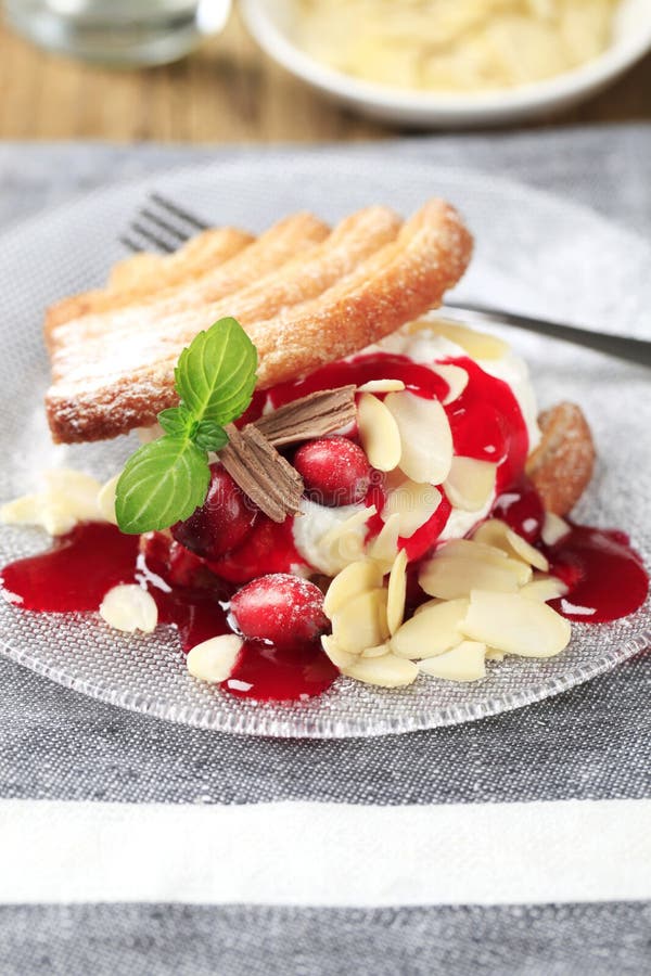 Fan-shaped puff pastries with cream, cranberries and syrup. Fan-shaped puff pastries with cream, cranberries and syrup