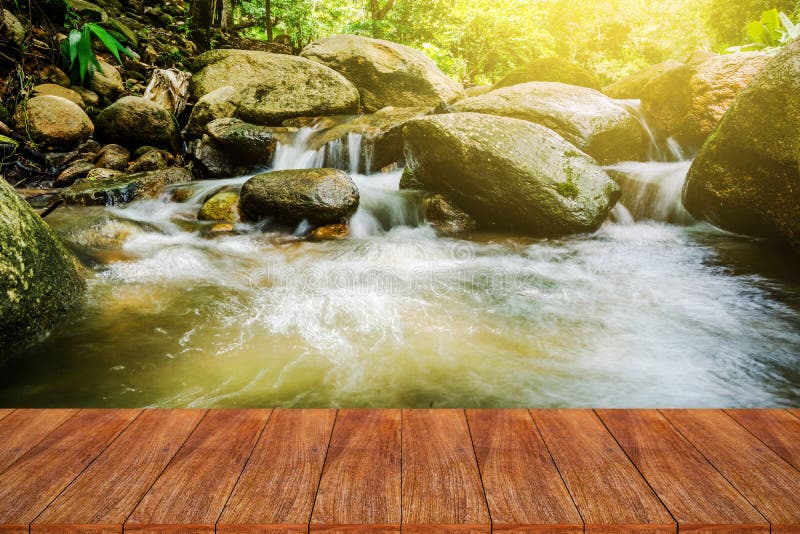 Sobremesa de madera en la cascada natural de la falta de definición con luz del sol imagen de archivo Sobremesa de madera en la cascada natural de la falta de definición con luz del sol imagen de archivo