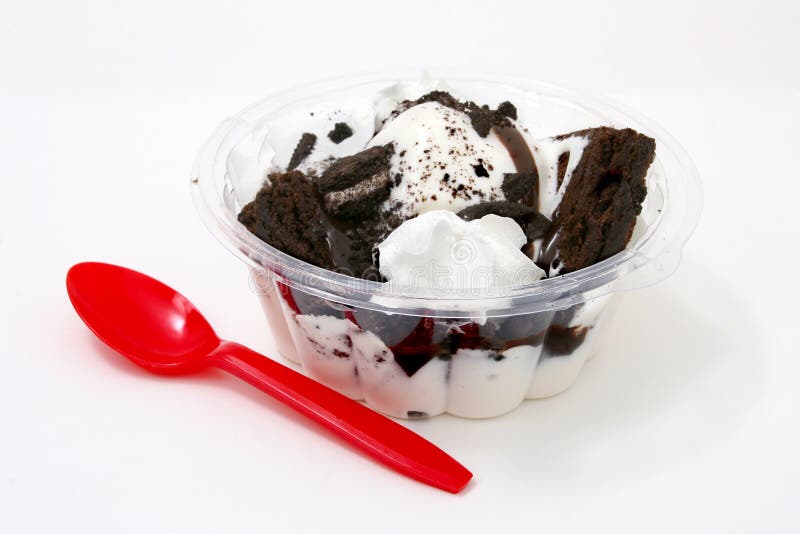 Clear plastic bowl with vanilla icecream, brownie, cookies, whipped cream with a red plastic spoon. Shot with the Canon 20D. Clear plastic bowl with vanilla icecream, brownie, cookies, whipped cream with a red plastic spoon. Shot with the Canon 20D.