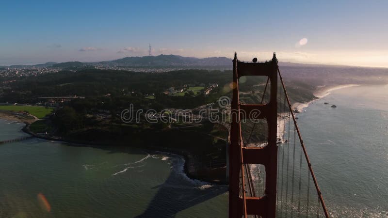 Sobrevoando a ponte dourada perto da torre sul em direção à paisagem ensolarada de san francisco presidio rocky shore sunny day