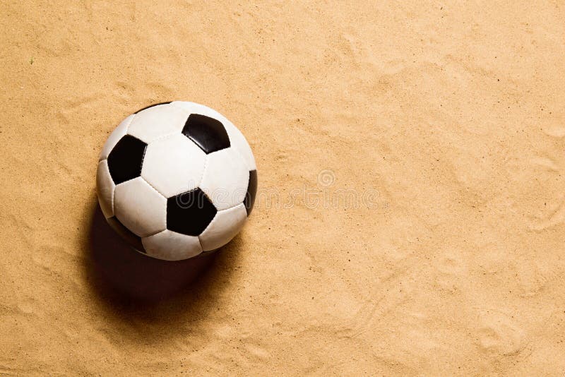 Soccer ball against sandy beach. Studio shot. Copy space.