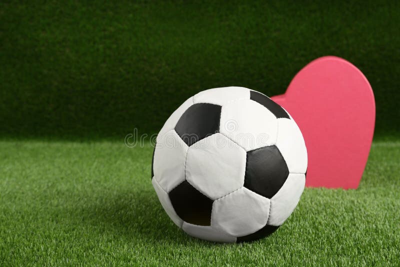 Soccer Ball and Heart on Green Grass. Space for Text Stock Image