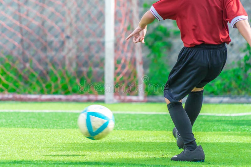 Soccer Boy Training Kicking the Ball in Soccer Training Field Stock