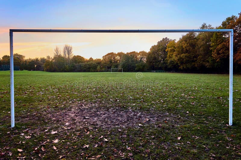 Small yellow football goals on a stadium field during autumn