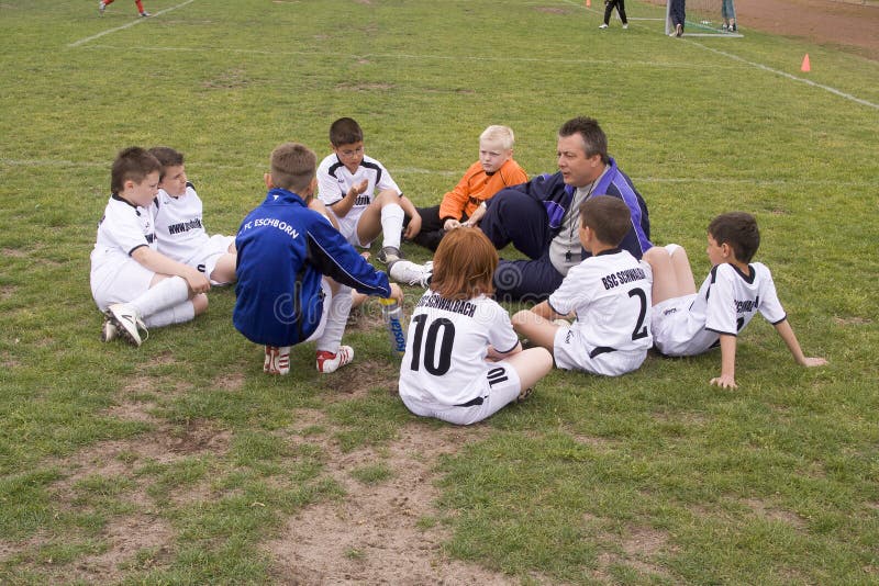 Socctrainer da consejo al jugador de los jóvenes er foto de archivo
