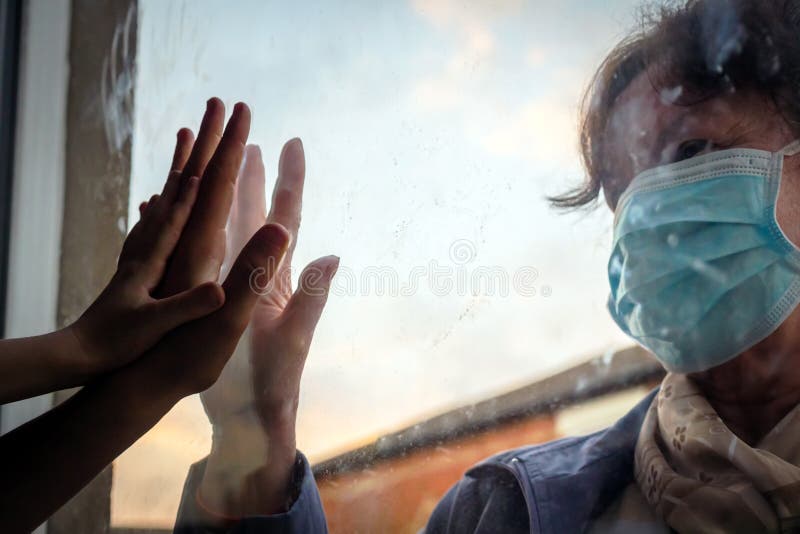 Social distancing among the family, hand of the woman and her grandchildren on window plane, concept coronavirus and