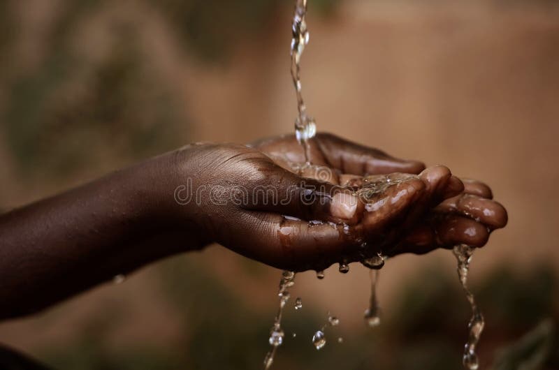 Water Spilling Into Black African Children`s Hands Drought / Water Scarcity symbol. Water scarcity is the lack of sufficient available water resources to meet the demands of water usage. Water Spilling Into Black African Children`s Hands Drought / Water Scarcity symbol. Water scarcity is the lack of sufficient available water resources to meet the demands of water usage.