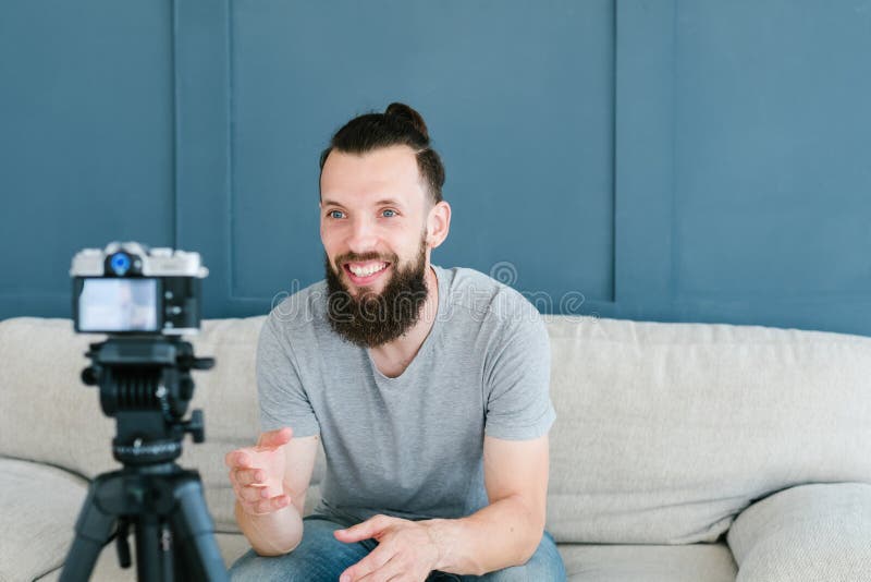 Social media influencer creating content. man shooting video of himself using camera on tripod. smiling bearded hipster guy communicating with subscribers. Social media influencer creating content. man shooting video of himself using camera on tripod. smiling bearded hipster guy communicating with subscribers.