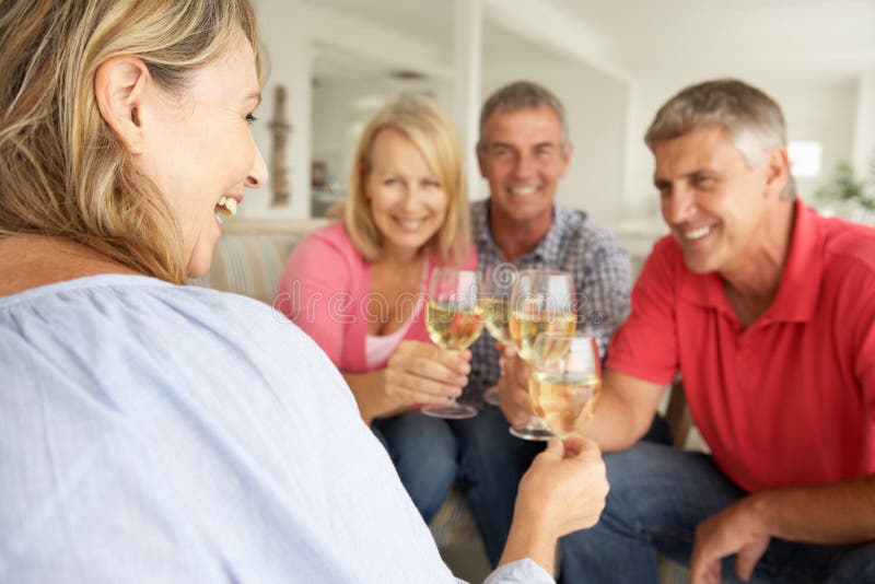 Sociale medio leeftijdsparen die samen thuis drinken stock fotografie Sociale medio leeftijdsparen die samen thuis drinken stock fotografie