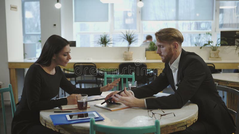 Socios comerciales en la reunión La señora discute estrategia con un hombre