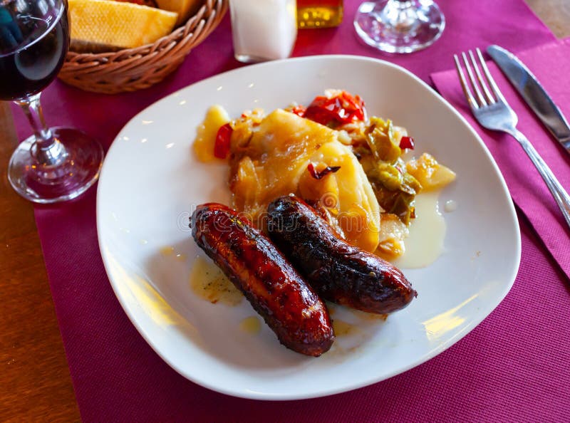 Juicy grilled creole sausages served with stewed vegetables and potatoes. Juicy grilled creole sausages served with stewed vegetables and potatoes